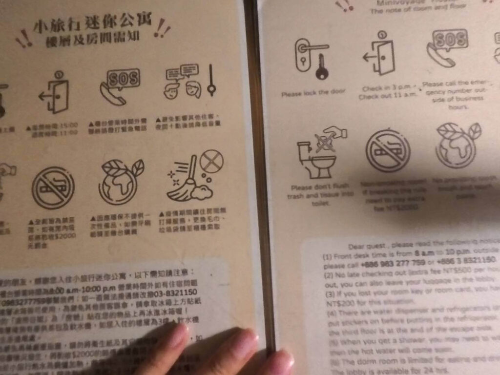 小旅行迷你公寓中英文入住須知：一份詳細的樓層及房間須知公告。內容包含插圖說明的入退房時間（Check in 15:00、Check out 11:00）、緊急聯繫電話、禁止吸菸與環保政策（不提供一次性備品）等重要資訊，右側則提供對應的英文版本，方便各國旅客閱讀。
