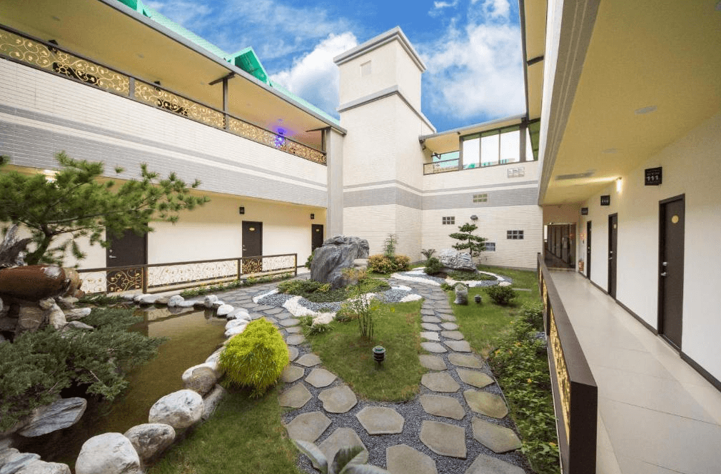 東大門精緻旅店的中庭景觀,採日式庭園設計,設有蜿蜒的石板步道、假山造景、小魚池以及綠色植栽,營造出寧靜悠閒的戶外氛圍。