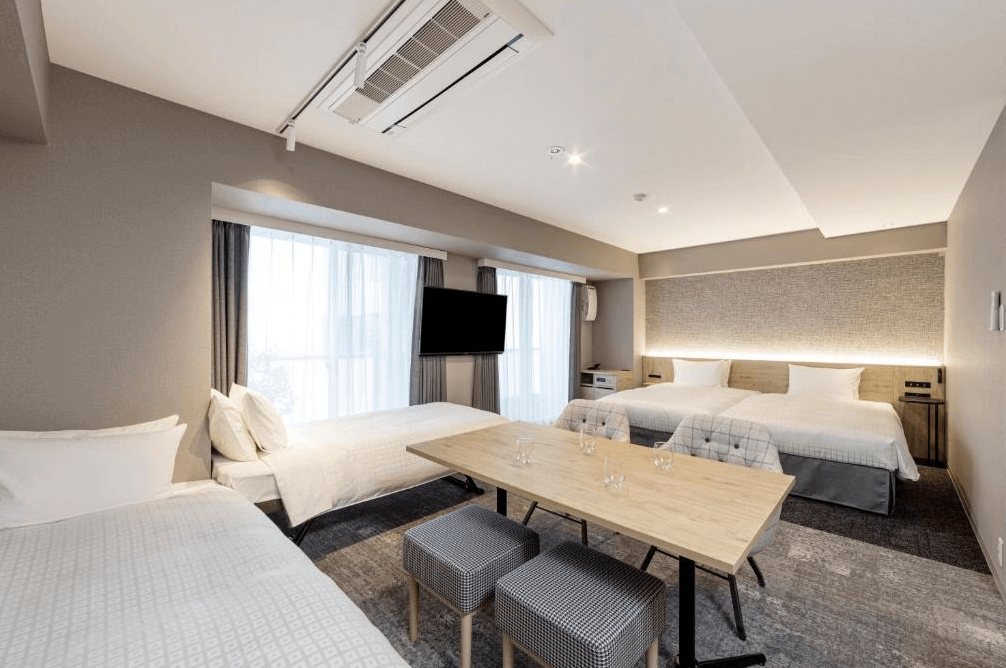 東急Stay澀谷寬敞家庭房，空間設計簡約溫馨，配置三張舒適單人床與木質餐桌椅，非常適合家庭或好友團體入住，讓旅客在東京也能享受如家一般的聚會時光。