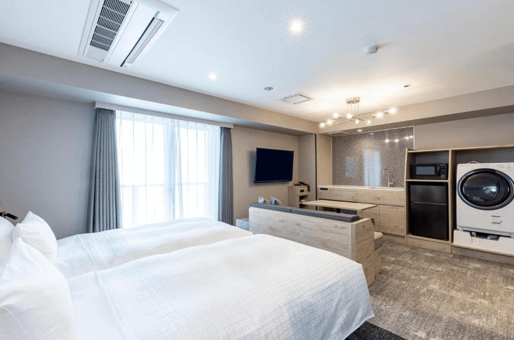 東急Stay澀谷機能型客房，最大的亮點是房內配備專屬的洗脫烘衣機與微波爐小廚房，搭配寬敞的沙發休憩區，為長住旅客或親子家庭提供極致便利的生活機能。