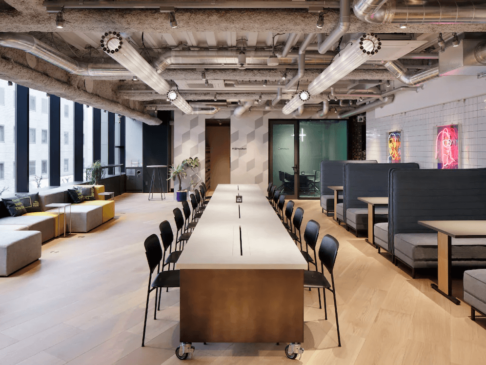 澀谷千禧旅館的共用工作空間（Co-working Space），擁有極佳的採光與寬敞的長桌座位，天花板保留工業風管線設計，並配有會議室與休閒沙發區，非常適合數位遊牧民族在此辦公。