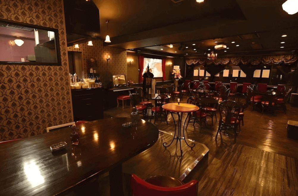 青山櫻花飯店附設復古餐廳，空間採用深色木質地板搭配典雅的紅色絨布座椅，燈光微醺柔和，充滿濃厚的昭和懷舊與歐式沙龍交織的獨特氣息。