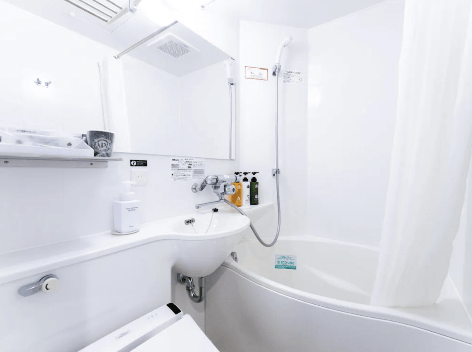 APA飯店-淺草雷門客房內的精緻衛浴空間，採用一體成型設計，包含免治馬桶、洗手台與浴缸洗浴區，整潔且功能齊全