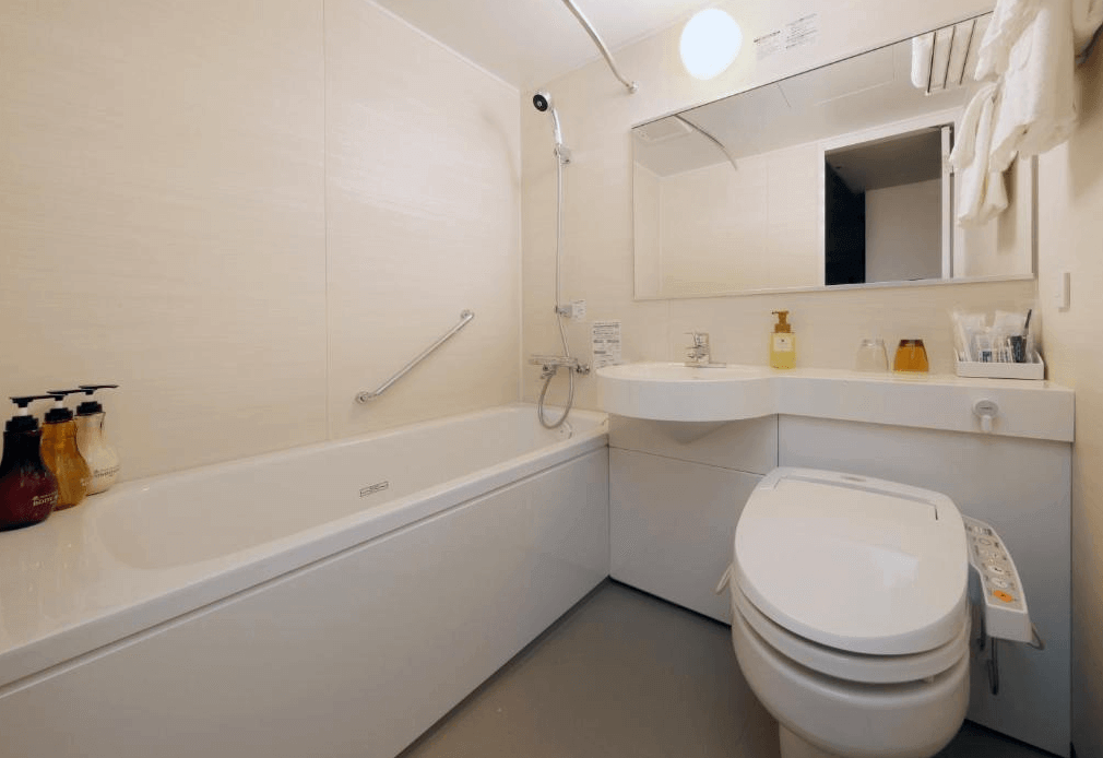 京王布萊索飯店東京站八重洲明亮潔淨的衛浴空間，採用標準的日式一體化設計，配備免治馬桶、洗手台與深型浴缸，並貼心提供大瓶裝的優質洗浴備品。