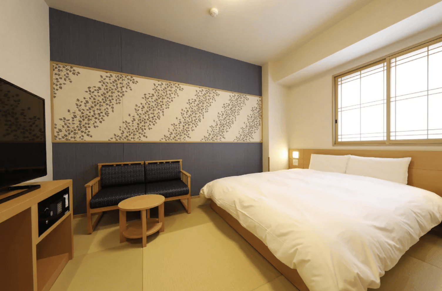 凌雲之湯 御宿野乃客房實景，房內舖設榻榻米，配有寬敞大床、雙人沙發與木質茶几，營造溫馨的和風氛圍