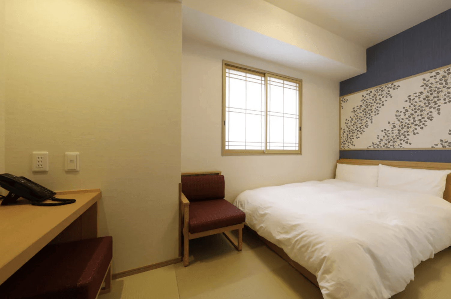 凌雲之湯 御宿野乃客房一角，設有簡約木質書桌與紅色單人椅，展現現代與傳統融合的舒適住宿感