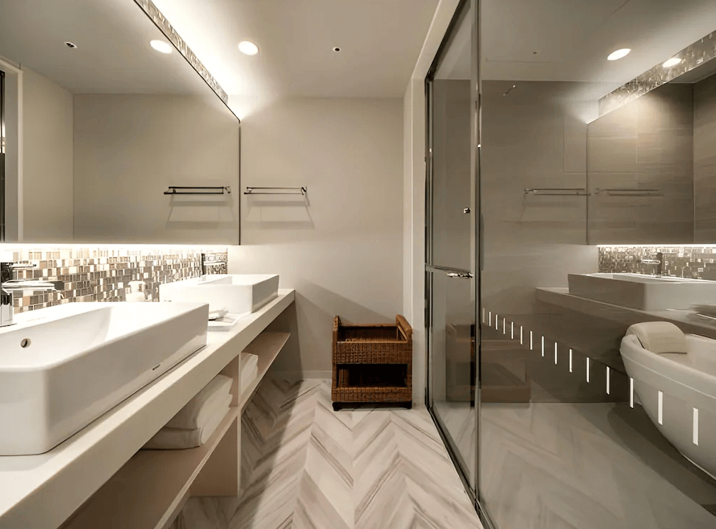 東京京橋大及魯內普米爾飯店豪華衛浴空間，採用質感大理石紋地磚與明亮的間接照明，配備雙洗手台設計以及寬敞的乾濕分離獨立深型浴缸，展現頂級飯店的衛浴規格。