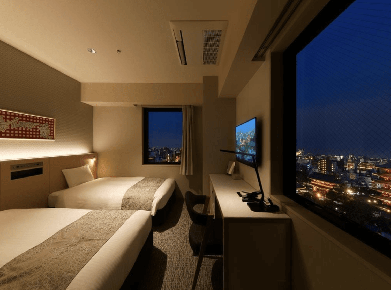 東京淺草簪飯店 (THE KANZASHI TOKYO ASAKUSA) 的雙床房型實景，客房裝潢簡約溫馨，大面窗景可直接飽覽東京晴空塔與璀璨的城市夜景
