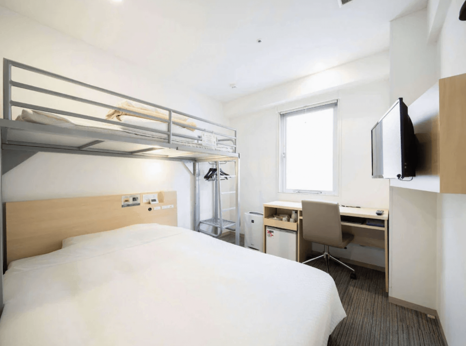 淺草超級酒店的客房實景，房內設有舒適的雙人床與上層高架單人床位，並配備書桌、壁掛電視及空氣清淨機，空間利用極佳