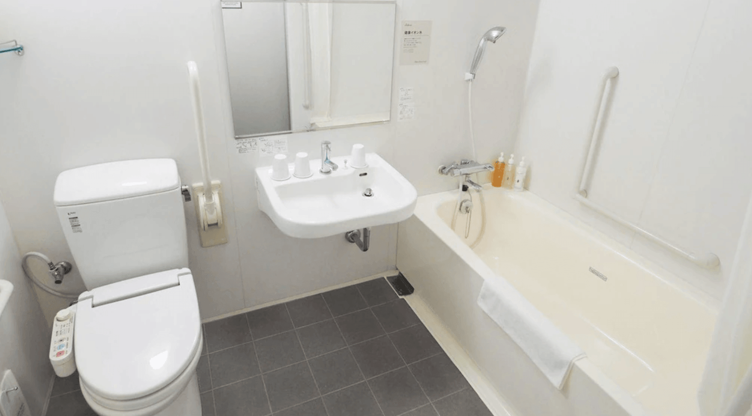 淺草超級酒店的衛浴空間，採用日式一體成型設計，包含免治馬桶、洗手台以及備有安全扶手的浴缸淋浴區，乾淨且功能齊全