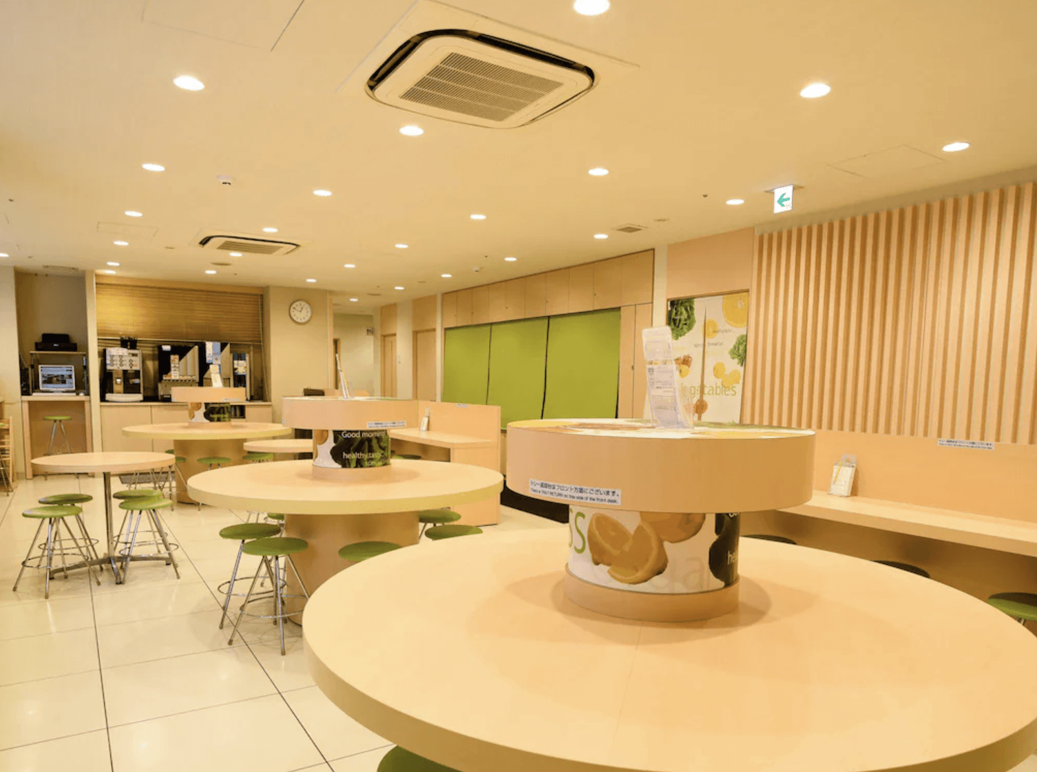 淺草超級酒店的大廳與早餐用餐區，室內空間開闊明亮，設置多組圓形高腳餐桌，後方設有咖啡與飲料自助吧供房客免費享用