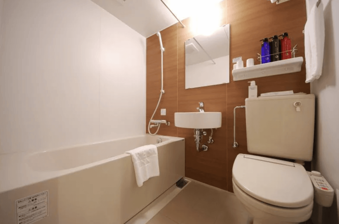 相鐵 Fresa Inn - 銀座七丁目的浴室全景。採用典型的日式一體成型衛浴（Unit Bath）設計，包含洗手台、免治馬桶與浴缸，並備有齊全的洗沐備品與大毛巾。
