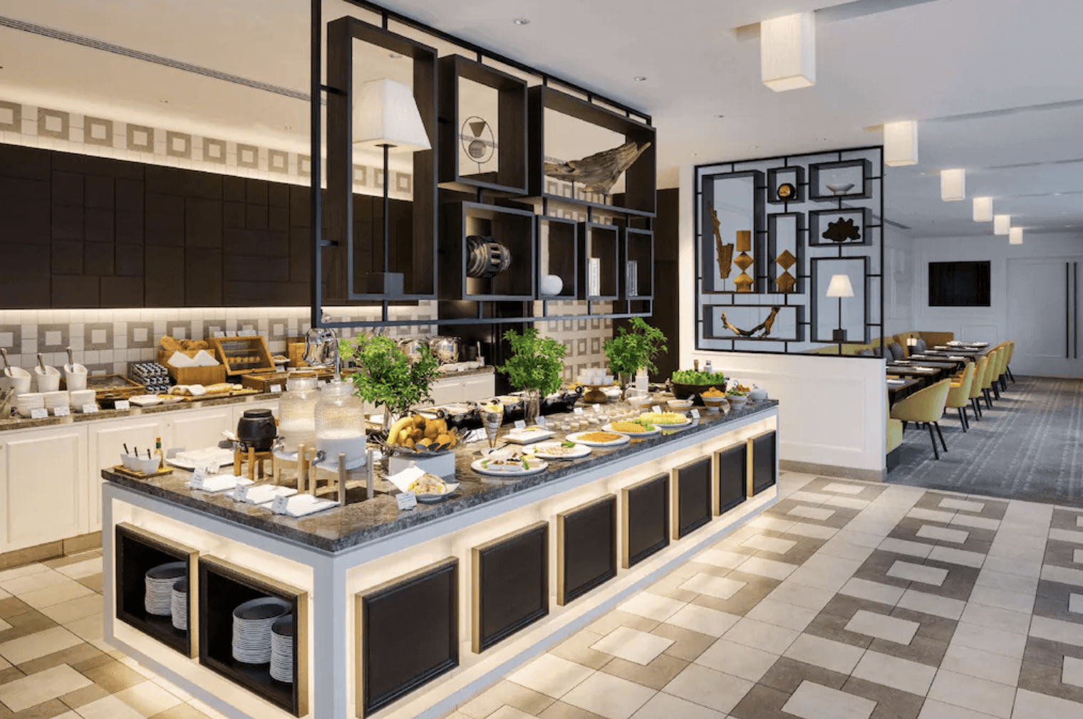 大阪希爾頓飯店現代自助餐餐廳。擺滿各種精緻食物的大理石自助餐檯位於中心，背景是帶有現代設計和黃色椅子的用餐區