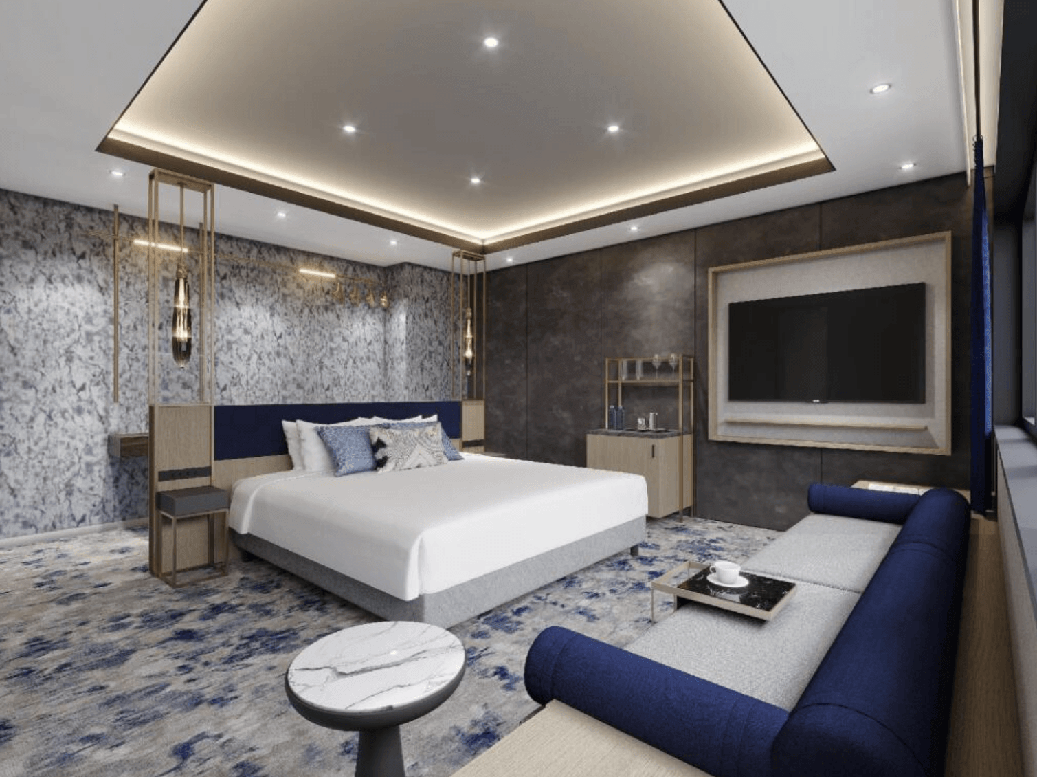 溫泉世界飯店及度假村 (SPAWORLD HOTEL&RESORT) 的現代化客房，鋪設藍灰相間的圖騰地毯。房內配置寬敞的雙人床、深藍色長沙發、大理石紋圓桌與壁掛式平面電視，整體風格沉穩且時尚
