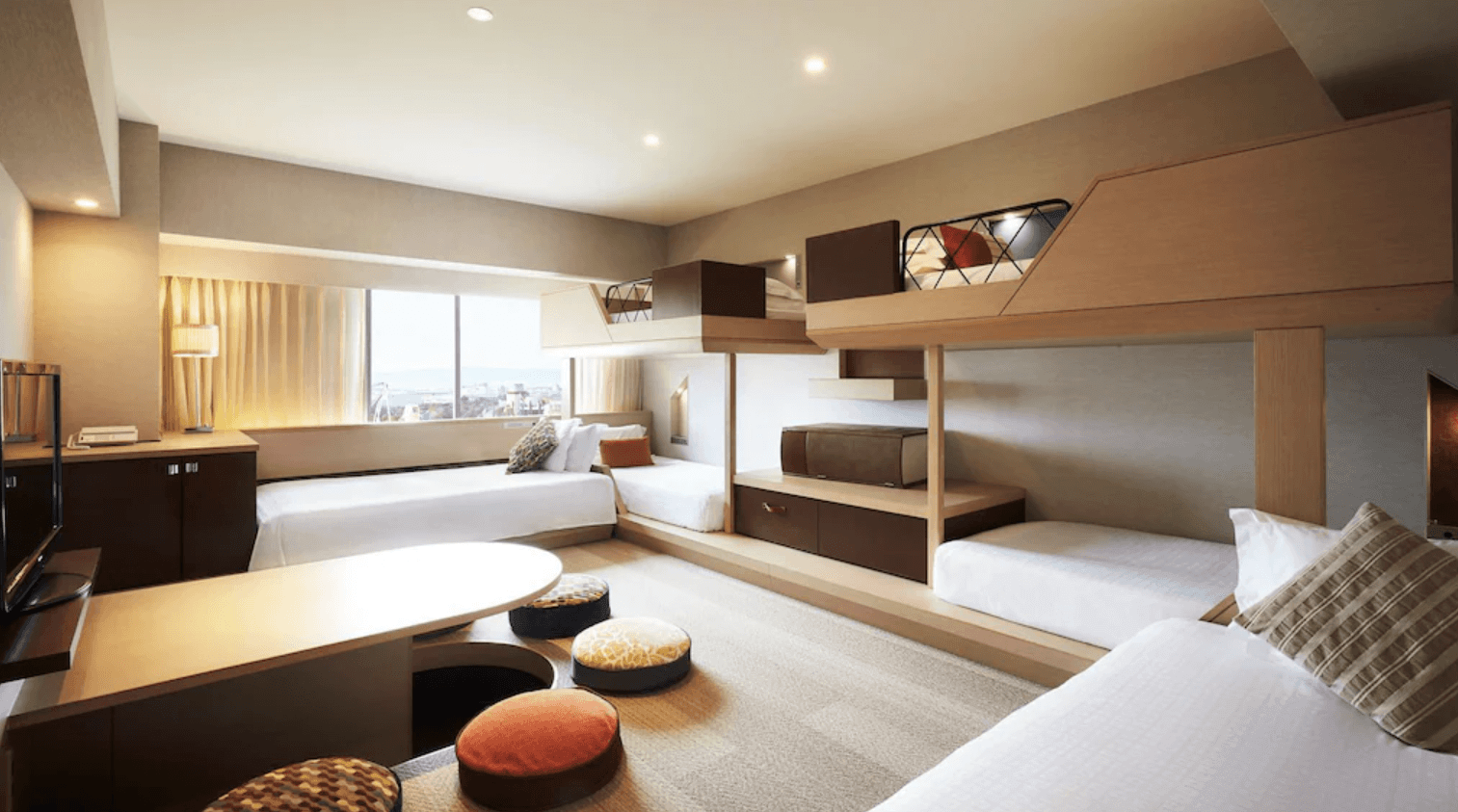 環球影城港灣酒店 (Hotel Universal Port) 的木質家庭客房,設有節省空間的木製上下舖床位,並配有一個帶有彩色圓形坐墊的下凹式和室桌區域