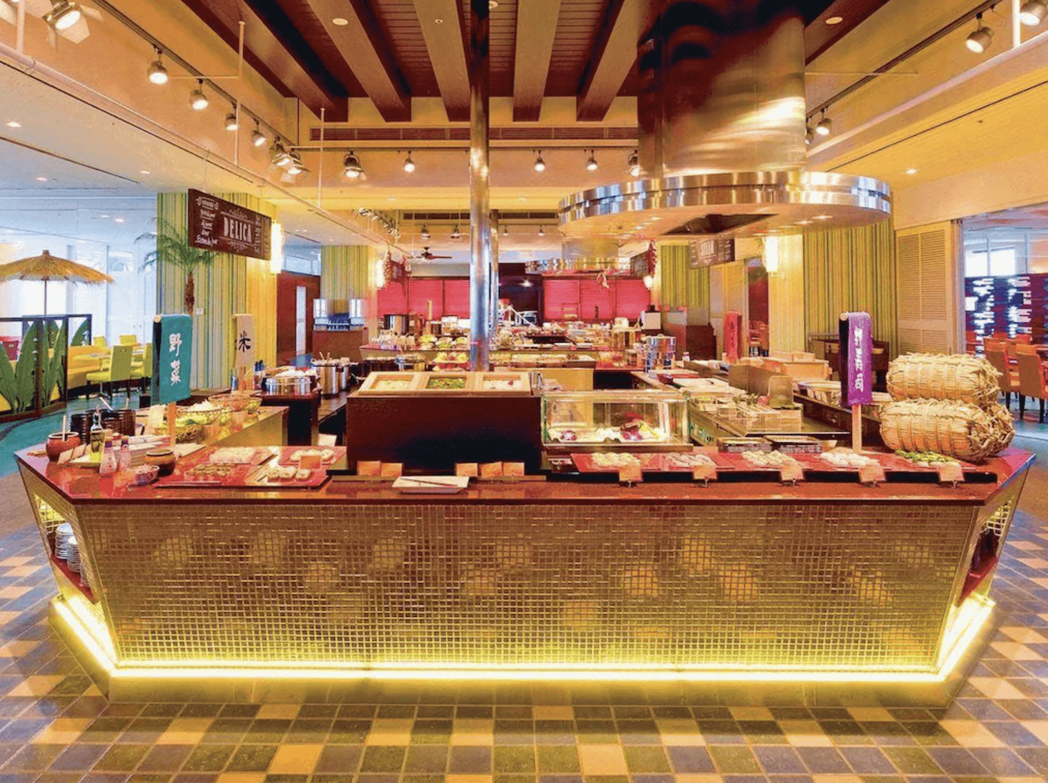環球影城港灣酒店 (Hotel Universal Port) 的自助餐廳,環境明亮且裝潢色彩豐富,中央設有大型發光取餐吧檯與金屬排煙罩,提供多樣化的餐飲選擇