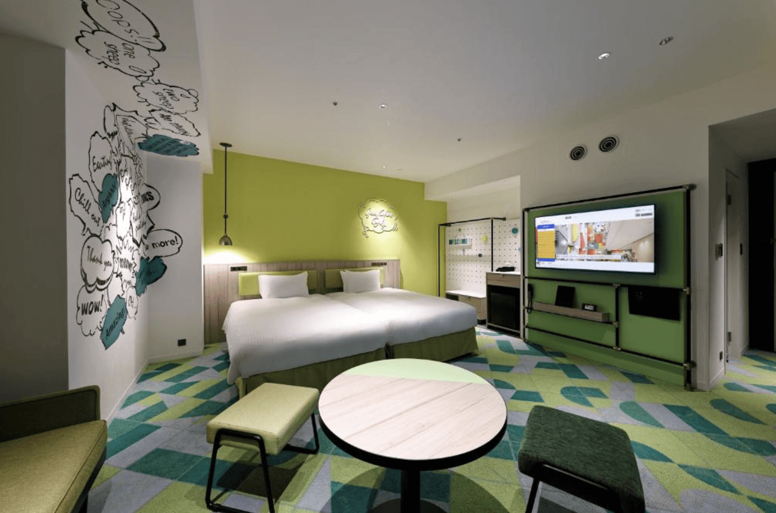 近鐵環球城飯店 (Hotel Kintetsu Universal City) 的綠色主題雙床客房。房內鋪設綠白相間的幾何拼色地毯,柱面裝飾著充滿童趣的黑白漫畫對話框塗鴉,並配備工業風的綠色壁掛電視牆、兩張單人床以及簡約的圓桌與小座椅